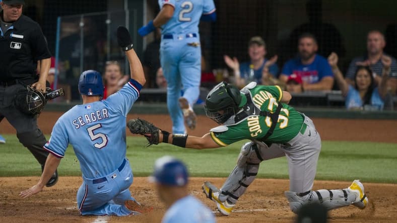 Sep 10, 2023; Arlington, Texas, USA; Texas Rangers shortstop Corey Seager (5) slides past the tag of Oakland Athletics catcher Tyler Soderstrom (37) during the fifth inning at Globe Life Field. Mandatory Credit: Jerome Miron-USA TODAY Sports
