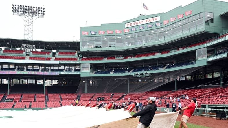 Sep 11, 2023; Boston, Massachusetts, USA; The grounds crew covers the infield with a tarp before a game between the New York Yankees and the Boston Red Sox at Fenway Park. Mandatory Credit: Brian Fluharty-USA TODAY Sports