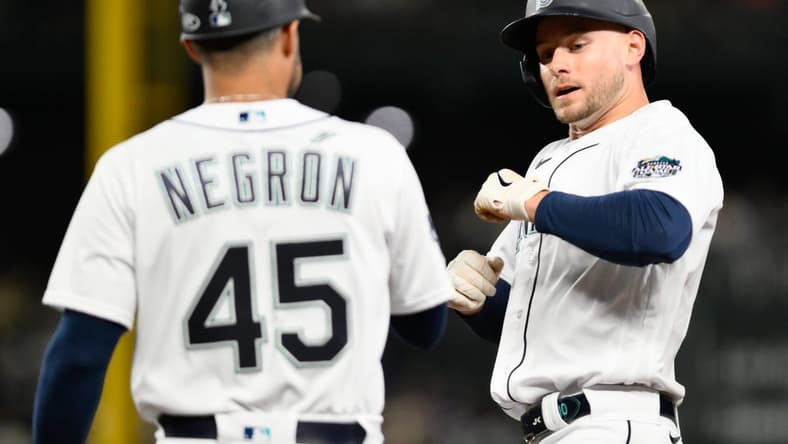 Sep 11, 2023; Seattle, Washington, USA; Seattle Mariners right fielder Jarred Kelenic (10) celebrates with first base coach Kristopher Negr  n (45) after hitting a single against the Los Angeles Angels during the fifth inning at T-Mobile Park. Mandatory Credit: Steven Bisig-USA TODAY Sports