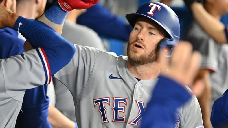 Sep 12, 2023; Toronto, Ontario, CAN;   Texas Rangers right fielder Robbie Grossman (4) celebrates with team mates in the dugout after hitting a two run home run against the Toronto Blue Jays in the fourth inning at Rogers Centre. Mandatory Credit: Dan Hamilton-USA TODAY Sports