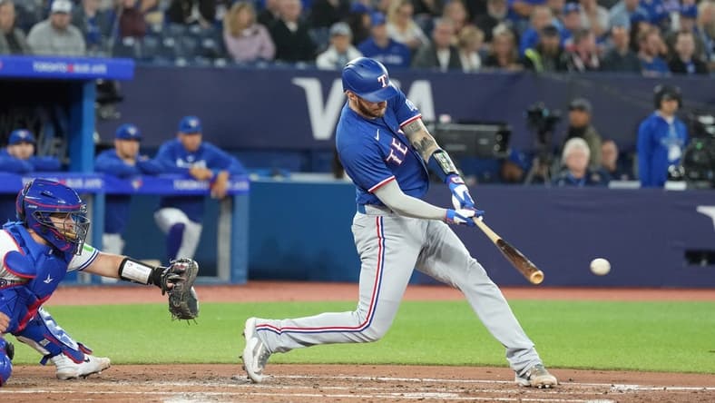 Sep 13, 2023; Toronto, Ontario, CAN; Texas Rangers catcher Jonah Heim (28) hits an RBI single against the Toronto Blue Jays during the fourth inning at Rogers Centre. Mandatory Credit: Nick Turchiaro-USA TODAY Sports