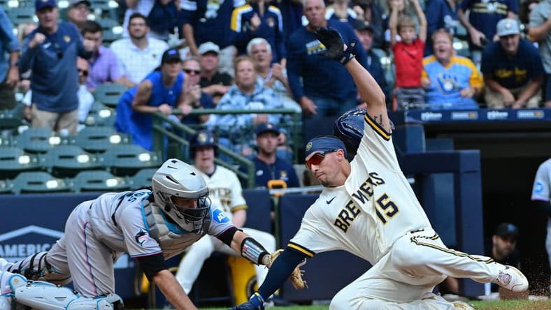 Sep 14, 2023; Milwaukee, Wisconsin, USA; Milwaukee Brewers left fielder Tyrone Taylor (15) scores past Miami Marlins catcher Jacob Stallings (58) in the fifth inning at American Family Field. Mandatory Credit: Benny Sieu-USA TODAY Sports