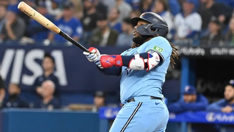 Sep 14, 2023; Toronto, Ontario, CAN;   Toronto Blue Jays first baseman Vladimir Guerrero Jr. (27) hits a two run home run against the Texas Rangers in the first inning at Rogers Centre. Mandatory Credit: Dan Hamilton-USA TODAY Sports