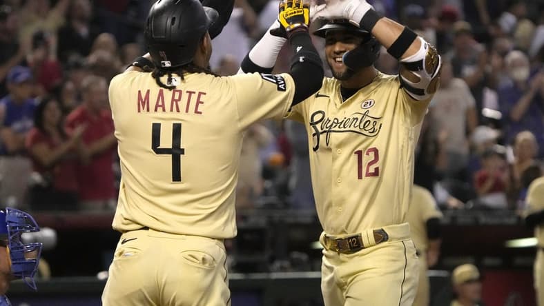 Sep 15, 2023; Phoenix, Arizona, USA; Arizona Diamondbacks left fielder Lourdes Gurriel Jr. (12) celebrates with second baseman Ketel Marte (4) after hitting a three run home run against the Chicago Cubs in the first inning at Chase Field. Mandatory Credit: Rick Scuteri-USA TODAY Sports