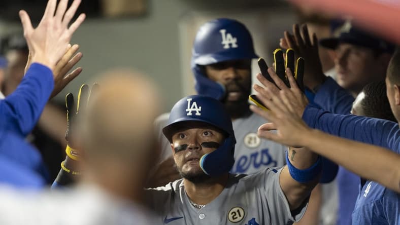 Sep 15, 2023; Seattle, Washington, USA; Los Angeles Dodgers shortstop Miguel Rojas (11) is congratulated by teammates in the dugout after hitting a two-run home run against the Seattle Mariners at T-Mobile Park. Mandatory Credit: Stephen Brashear-USA TODAY Sports