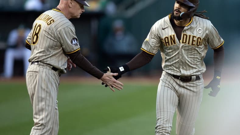 Sep 15, 2023; Oakland, California, USA; San Diego Padres right fielder Fernando Tatis Jr. (right) gets a congratulatory handshake from third base coach Matt Williams (18) after hitting a solo home run against the Oakland Athletics during the first inning at Oakland-Alameda County Coliseum. Mandatory Credit: D. Ross Cameron-USA TODAY Sports