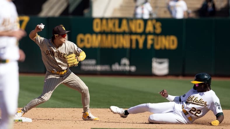 Sep 16, 2023; Oakland, California, USA; San Diego Padres second baseman Ha-Seong Kim (7) throws over Oakland Athletics center fielder Lawrence Butler (22) to complete a double play during the sixth inning at Oakland-Alameda County Coliseum. Mandatory Credit: D. Ross Cameron-USA TODAY Sports