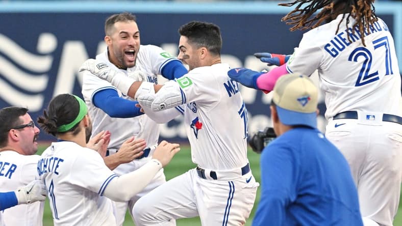 Sep 16, 2023; Toronto, Ontario, CAN; Toronto Blue Jays left fielder Whit Merrifield (15) celebrates with teammates after driving in the winning run against the Boston Red Sox in the 13th inning at Rogers Centre. Mandatory Credit: Dan Hamilton-USA TODAY Sports