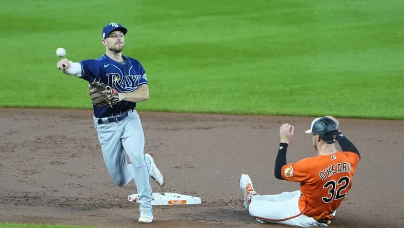 Sep 16, 2023; Baltimore, Maryland, USA;  Tampa Bay Rays second baseman Brandon Lowe (8) turns a double play with Baltimore Orioles first baseman Ryan O'Hearn (32) sliding into second base during the first inning at Oriole Park at Camden Yards. Mandatory Credit: Gregory Fisher-USA TODAY Sports
