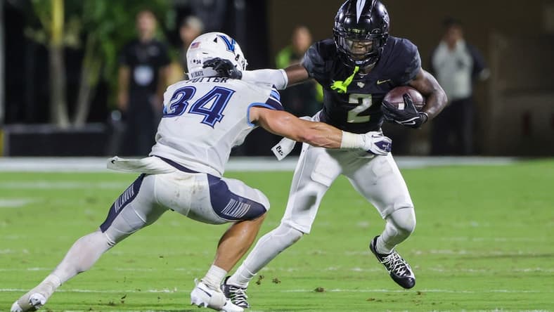 Sep 16, 2023; Orlando, Florida, USA; UCF Knights wide receiver Kobe Hudson (2) runs the ball as Villanova Wildcats defensive back Ethan Potter (34) moves in during the second quarter at FBC Mortgage Stadium. Mandatory Credit: Mike Watters-USA TODAY Sports
