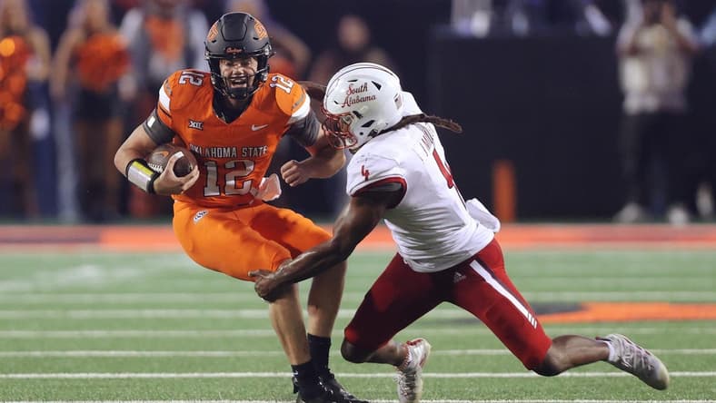 Sep 16, 2023; Stillwater, Oklahoma, USA; Oklahoma State Cowboys quarterback Gunnar Gundy (12) tries to get past South Alabama Jaguars linebacker James Miller (4) during an NCAA football game between Oklahoma State and South Alabama at Boone Pickens Stadium. South Alabama won 33-7. Mandatory Credit: Bryan Terry-USA TODAY Sports