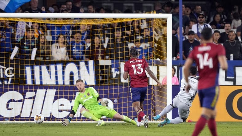 Sep 16, 2023; San Jose, California, USA; Real Salt Lake goalkeeper Zac MacMath (in green) allows a goal by San Jose Earthquakes forward Jeremy Ebobisse (right in gray) during the first half at PayPal Park. Mandatory Credit: Darren Yamashita-USA TODAY Sports