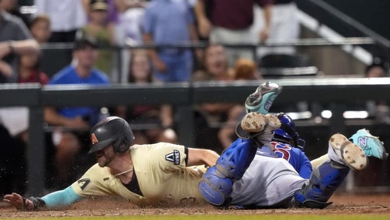 Sep 16, 2023; Phoenix, Arizona, USA; Arizona Diamondbacks pinch hitter Evan Longoria (3) slides at home and beats the tag of Chicago Cubs catcher Yan Gomes (15) to score the game winning run during the 13th inning at Chase Field. Mandatory Credit: Joe Camporeale-USA TODAY Sports