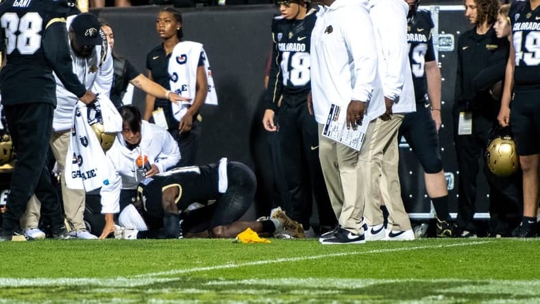 CU football's sophomore athlete Travis Hunter crumples in pain as a yellow penalty flag hits the ground following an illegal hit along the sideline by a CSU defender during the Rocky Mountain Showdown on Sept. 16, 2023 at Folsom Field in Boulder, Colo.