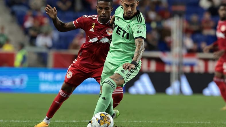 Sep 20, 2023; Harrison, New Jersey, USA; Austin FC midfielder Emiliano Rigoni (7) and New York Red Bulls defender Kyle Duncan (6) battle for the ball in the second half at Red Bull Arena. Mandatory Credit: Vincent Carchietta-USA TODAY Sports