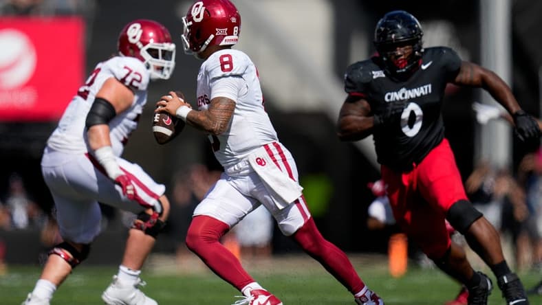 Oklahoma Sooners quarterback Dillon Gabriel (8) scrambles away from Cincinnati Bearcats defensive end Jowon Briggs (0) in the fourth quarter of the NCAA Big 12 football game between the Cincinnati Bearcats and the Oklahoma Sooners at Nippert Stadium in Cincinnati on Saturday, Sept. 23, 2023. The Bearcats lost their first Big 12 football game, 20-6, to the Sooners before a sellout crowd.