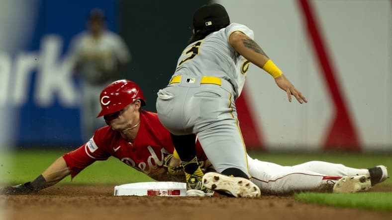 Sep 23, 2023; Cincinnati, Ohio, USA; Cincinnati Reds center fielder TJ Friedl (29) steals second as Pittsburgh Pirates second baseman Ji Hwan Bae (3) attempts to tag him in the seventh inning at Great American Ball Park. Mandatory Credit: The Cincinnati Enquirer-USA TODAY Sports