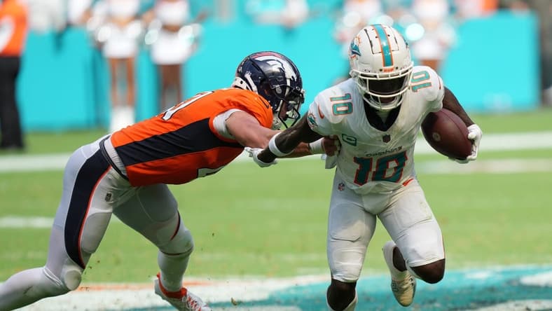 Miami Dolphins wide receiver Tyreek Hill (10) eludes the tackle of Denver Broncos linebacker Drew Sanders (41) in the third quarter of an NFL game at Hard Rock Stadium in Miami Gardens, Sept. 24, 2023.