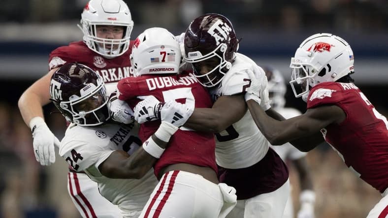 Sep 30, 2023; Arlington, Texas, USA; Arkansas Razorbacks running back Rashod Dubinion (7) is tackled by Texas A&M Aggies linebacker Chris Russell Jr. (24) and defensive back Jacoby Mathews (2) during the first half at AT&T Stadium. Mandatory Credit: Jerome Miron-USA TODAY Sports