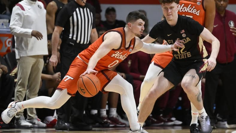 Mar 4, 2023; Blacksburg, Virginia, USA;Virginia Tech Hokies guard Hunter Cattoor (0) dribbles the ball against Florida State Seminoles guard Tom House (12) in the first half at Cassell Coliseum. Mandatory Credit: Lee Luther Jr.-USA TODAY Sports