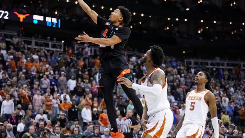 Mar 26, 2023; Kansas City, MO, USA; Miami (Fl) Hurricanes guard Nijel Pack (24) shoots against Texas Longhorns guard Tyrese Hunter (4) and guard Marcus Carr (5) during the second half of an Elite 8 college basketball game in the Midwest Regional of the 2023 NCAA Tournament at T-Mobile Center. Mandatory Credit: Jay Biggerstaff-USA TODAY Sports