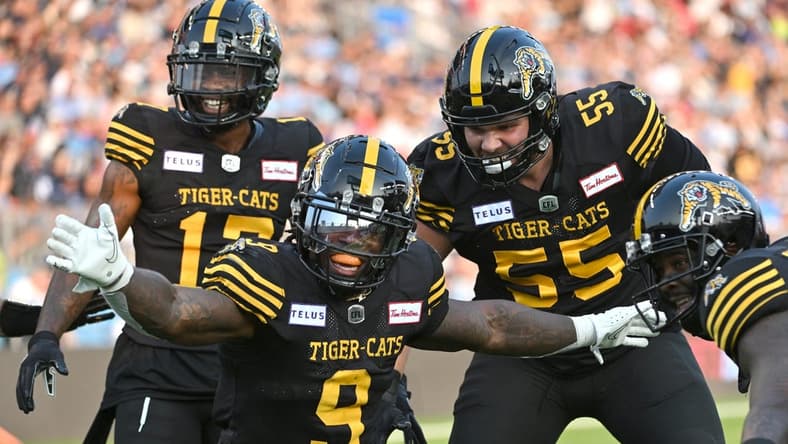 Jun 18, 2023; Toronto, Ontario, CAN; Hamilton Tiger-Cats quarter James Butler (9) celebrates with teammates after scoring a touchdown against the Toronto Argonauts in the second quarter at BMO Field. Mandatory Credit: Dan Hamilton-USA TODAY Sports