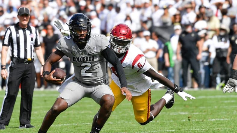 Sep 30, 2023; Boulder, Colorado, USA; Colorado Buffaloes quarterback Shedeur Sanders (2) attempts to scramble from USC Trojans defensive lineman Anthony Lucas (6) during the fourth quarter at Folsom Field. Mandatory Credit: John Leyba-USA TODAY Sports