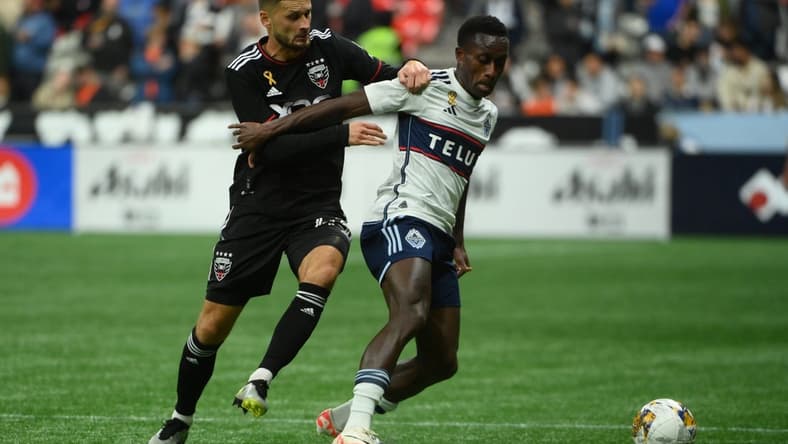 Sep 30, 2023; Vancouver, British Columbia, CAN; D.C. United midfielder Mateusz Klich (43) battles for the ball against Vancouver Whitecaps FC forward Richie Laryea (7) during the first half at BC Place. Mandatory Credit: Anne-Marie Sorvin-USA TODAY Sports