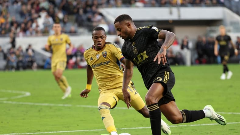 Oct 1, 2023; Los Angeles, California, USA;  Los Angeles FC defender Diego Palacios (12) dribbles the ball against Real Salt Lake forward Carlos Andres Gomez (11) during the first half at BMO Stadium. Mandatory Credit: Kiyoshi Mio-USA TODAY Sports