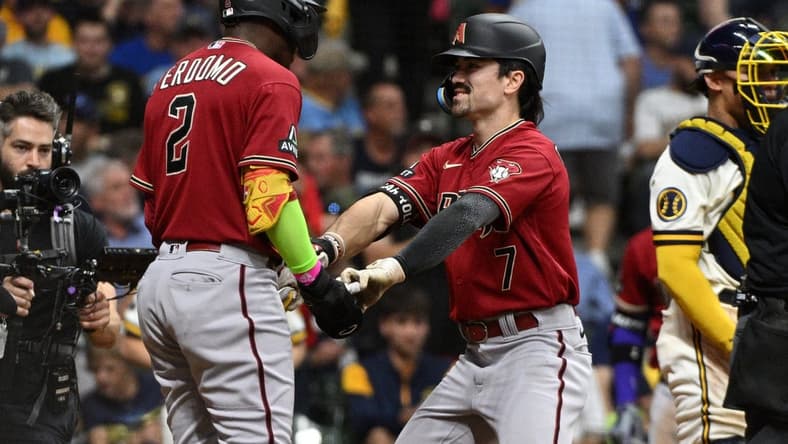 Oct 3, 2023; Milwaukee, Wisconsin, USA; Arizona Diamondbacks shortstop Geraldo Perdomo (2) and left fielder Corbin Carroll (7) celebrate scoring in the third inning against the Milwaukee Brewers during game one of the Wildcard series for the 2023 MLB playoffs at American Family Field. Mandatory Credit: Michael McLoone-USA TODAY Sports