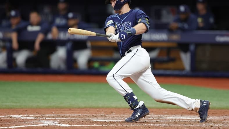 Oct 4, 2023; St. Petersburg, Florida, USA; Tampa Bay Rays second baseman Curtis Mead (25) hits an RBI single against the Texas Rangers in the seventh inning during game two of the Wildcard series for the 2023 MLB playoffs at Tropicana Field. Mandatory Credit: Nathan Ray Seebeck-USA TODAY Sports