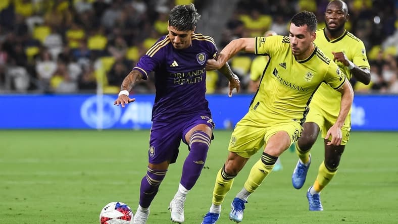 Oct 4, 2023; Nashville, Tennessee, USA; Orlando City forward Facundo Torres (17) dribbles the ball as Nashville SC defender Daniel Lovitz (2) defends during the first half at Geodis Park. Mandatory Credit: Christopher Hanewinckel-USA TODAY Sports