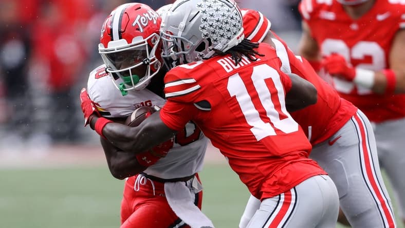 Oct 7, 2023; Columbus, Ohio, USA;  Maryland Terrapins wide receiver Tai Felton (10) runs the ball as Ohio State Buckeyes cornerback Denzel Burke (10) makes the tackle during the second quarter at Ohio Stadium. Mandatory Credit: Joseph Maiorana-USA TODAY Sports