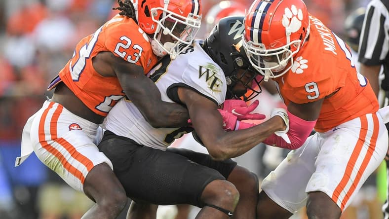 Oct 7, 2023; Clemson, South Carolina, USA; Clemson Tigers cornerback Toriano Pride Jr. (23) and safety R.J. Mickens (9) tackle Wake Forest Demon Deacons defensive back Justin Simpkins (80) during the fourth quarter at Memorial Stadium. Mandatory Credit: Ken Ruinard-USA TODAY Sports