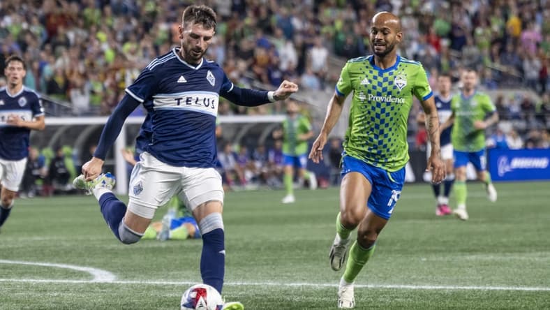 Oct 7, 2023; Seattle, Washington, USA; Vancouver Whitecaps defender Tristan Blackmon (6) passes the ball against Seattle Sounders forward Heber (19) during the second half at Lumen Field. Mandatory Credit: Stephen Brashear-USA TODAY Sports