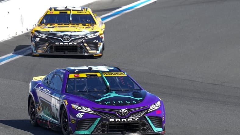 Oct 8, 2023; Concord, North Carolina, USA;  NASCAR Cup Series driver Tyler Reddick (45) leads driver Christopher Bell (20) out of turn eight during the Bank of America Roval 400 at Charlotte Motor Speedway Road Course. Mandatory Credit: Jim Dedmon-USA TODAY Sports