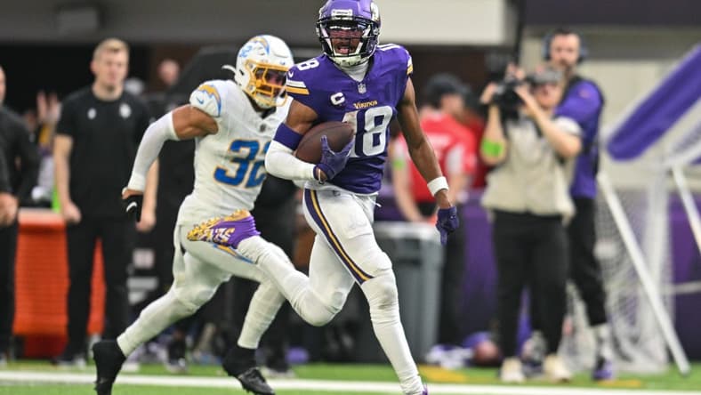 Sep 24, 2023; Minneapolis, Minnesota, USA; Minnesota Vikings wide receiver Justin Jefferson (18) scores on a touchdown pass as Los Angeles Chargers safety Alohi Gilman (32) chases from behind during the fourth quarter at U.S. Bank Stadium. Mandatory Credit: Jeffrey Becker-USA TODAY Sports