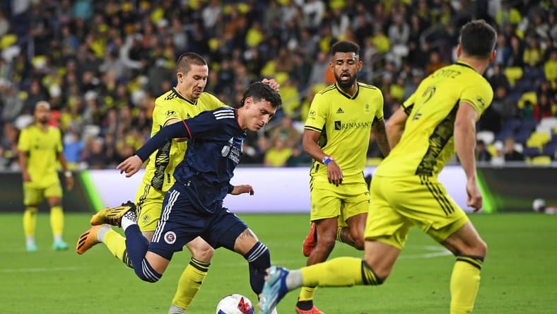 Oct 14, 2023; Nashville, Tennessee, USA; New England Revolution forward Tomas Chancalay (5) and Nashville SC midfielder Alex Muyl (19) battle for the ball during the first half at Geodis Park. Mandatory Credit: Christopher Hanewinckel-USA TODAY Sports