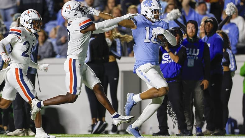 Oct 21, 2023; Chapel Hill, North Carolina, USA; North Carolina Tar Heels tight end Bryson Nesbit (18) scores a touchdown after a catch against Virginia Cavaliers safety Coen King (9) in the first half at Kenan Memorial Stadium. Mandatory Credit: Nell Redmond-USA TODAY Sports
