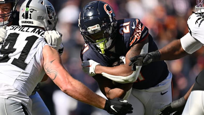 Oct 22, 2023; Chicago, Illinois, USA;  Chicago Bears running back D'Onta Foreman (21) fights through a tackle attempt from Las Vegas Raiders linebacker Robert Spillane (41) to score a touchdown in the second quarter at Soldier Field. Mandatory Credit: Jamie Sabau-USA TODAY Sports