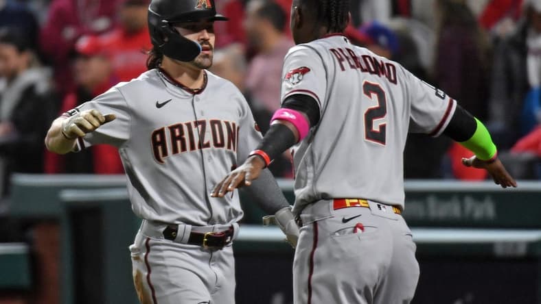 Oct 24, 2023; Philadelphia, Pennsylvania, USA; Arizona Diamondbacks left fielder Corbin Carroll (7) reacts with shortstop Geraldo Perdomo (2) after scoring a run in the fifth inning during game seven of the NLCS for the 2023 MLB playoffs at Citizens Bank Park. Mandatory Credit: Eric Hartline-USA TODAY Sports