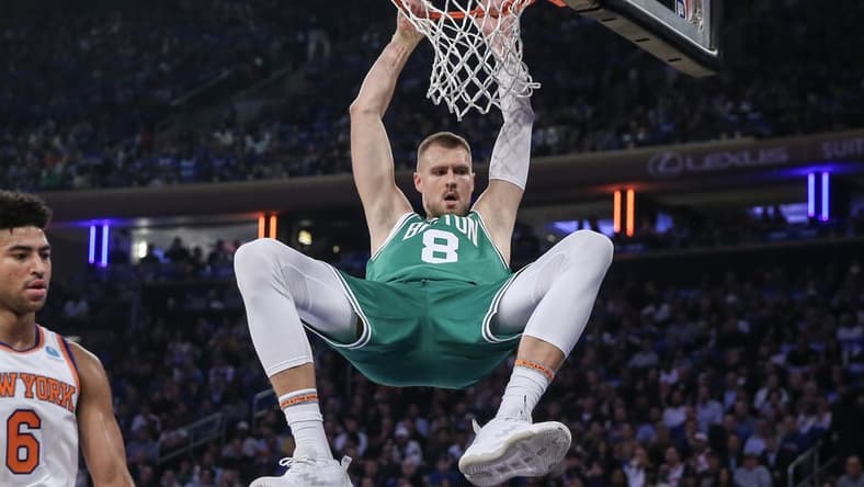Oct 25, 2023; New York, New York, USA; Boston Celtics center Kristaps Porzingis (8) hangs on the rim after a dunk in the first quarter against the New York Knicks at Madison Square Garden. Mandatory Credit: Wendell Cruz-USA TODAY Sports