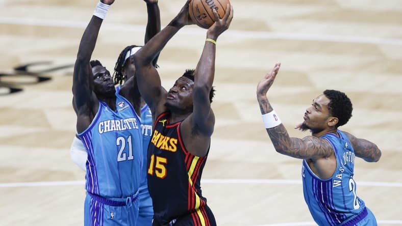 Oct 25, 2023; Charlotte, North Carolina, USA; Atlanta Hawks center Clint Capela (15) drives to the basket between Charlotte Hornets forwards JT Thor and P.J. Washington (25) during the second quarter at Spectrum Center. Mandatory Credit: Nell Redmond-USA TODAY Sports