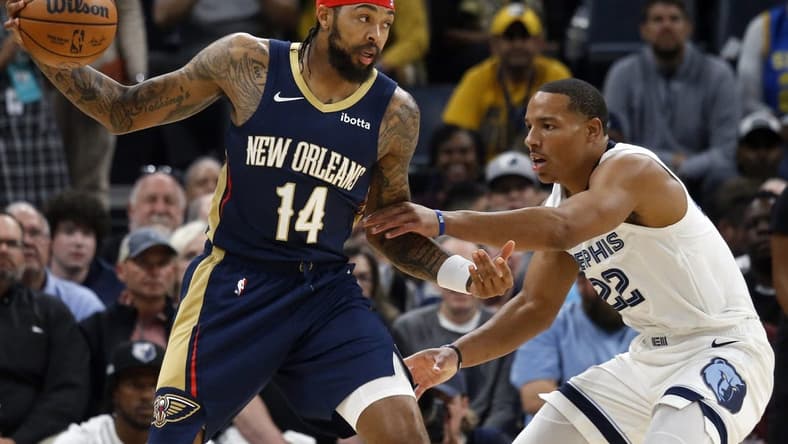 Oct 25, 2023; Memphis, Tennessee, USA; New Orleans Pelicans forward Brandon Ingram (14) catches a pass as Memphis Grizzlies guard Desmond Bane (22) defends during the first half at FedExForum. Mandatory Credit: Petre Thomas-USA TODAY Sports
