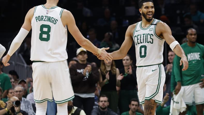 Oct 27, 2023; Boston, Massachusetts, USA; Boston Celtics forward Jayson Tatum (0) slaps hands with center Kristaps Porzingis (8) during the second quarter against the Miami Heat at TD Garden. Mandatory Credit: Winslow Townson-USA TODAY Sports