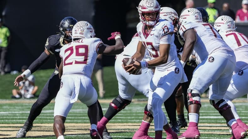 Oct 28, 2023; Winston-Salem, North Carolina, USA; Florida State Seminoles quarterback Jordan Travis (13) hands off the ball to running back Rodney Hill (29) during the first half against the Wake Forest Demon Deacons at Allegacy Federal Credit Union Stadium. Mandatory Credit: Jim Dedmon-USA TODAY Sports