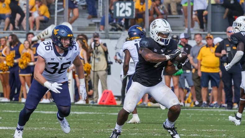 Oct 28, 2023; Orlando, Florida, USA; UCF Knights running back RJ Harvey (7) catches a pass in front of West Virginia Mountaineers linebacker Caden Biser (36) during the second half at FBC Mortgage Stadium. Mandatory Credit: Mike Watters-USA TODAY Sports