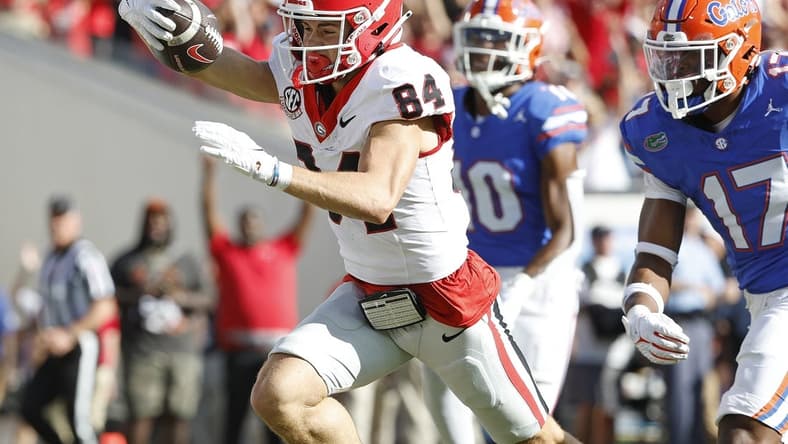 Oct 28, 2023; Jacksonville, Florida, USA; Georgia Bulldogs wide receiver Ladd McConkey (84) stretches for a touchdown past Florida Gators linebacker Scooby Williams (17) in the first half at EverBank Stadium. Mandatory Credit: Jeff Swinger-USA TODAY Sports