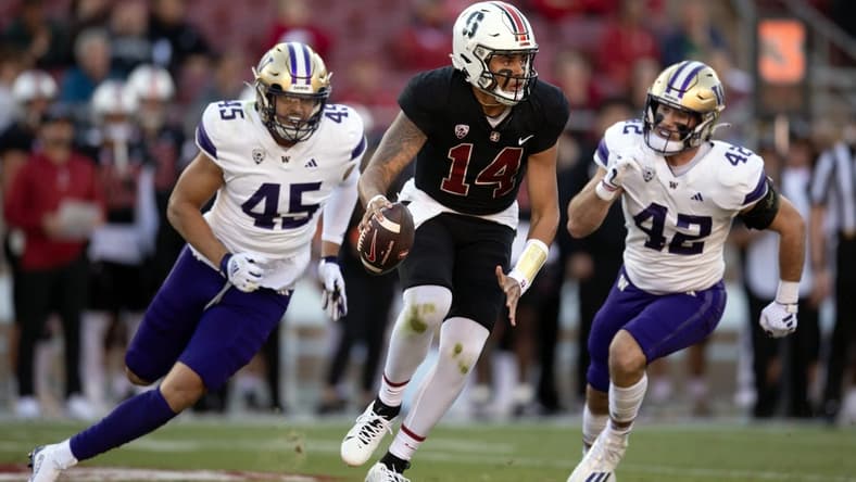 Oct 28, 2023; Stanford, California, USA; Stanford Cardinal quarterback Ashton Daniels (14) scrambles away from defensive pressure by Washington Huskies edge rusher Maurice Heims (45) and linebacker Carson Bruener (42) during the first quarter at Stanford Stadium. Mandatory Credit: D. Ross Cameron-USA TODAY Sports