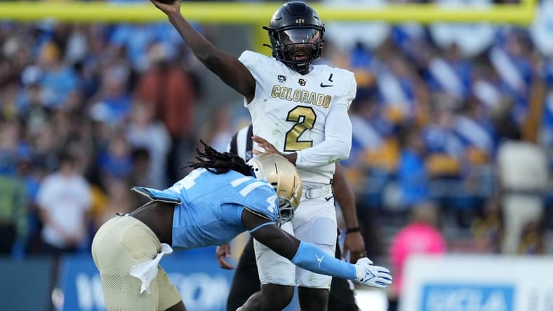 Oct 28, 2023; Pasadena, California, USA; UCLA Bruins quarterback Ethan Garbers (4) throws the ball against UCLA Bruins defensive lineman Carl Jones Jr. (4) in the first half at Rose Bowl. Mandatory Credit: Kirby Lee-USA TODAY Sports